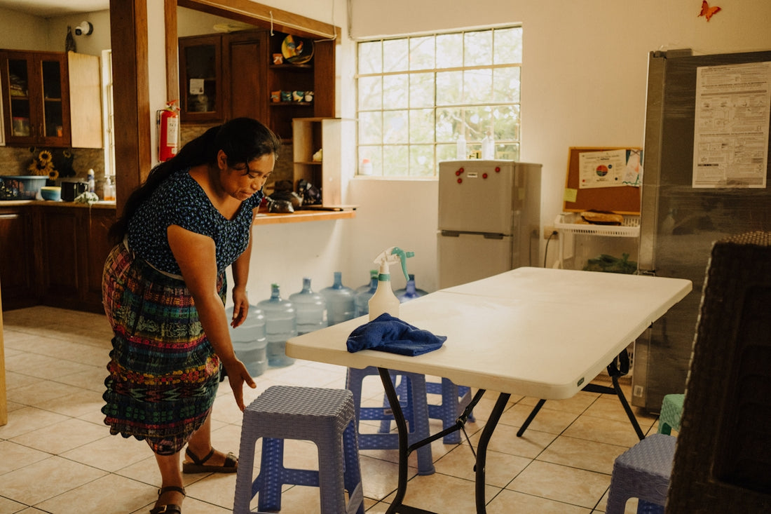 a woman standing in a kitchen next to a table