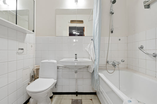A white bathroom with a tub, toilet and sink