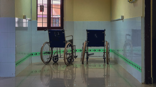 Two wheelchairs parked in a hallway.