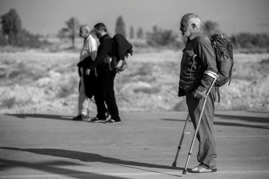grayscale photo of man with crutches