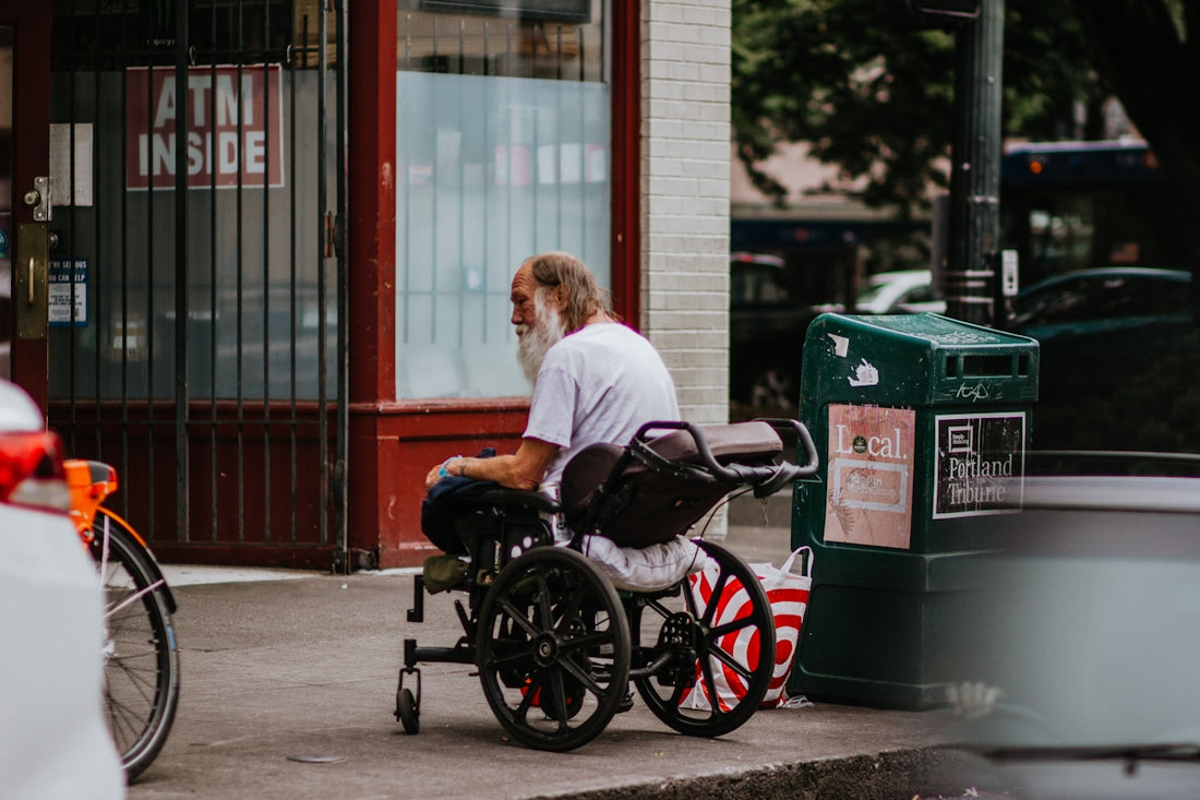man in white t-shirt sitting on black wheelchair