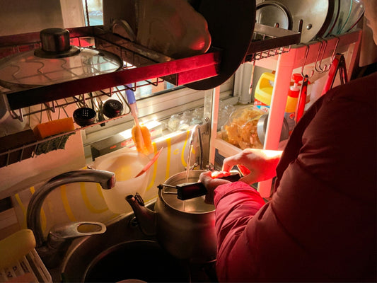 a woman in a red jacket is preparing food in a kitchen
