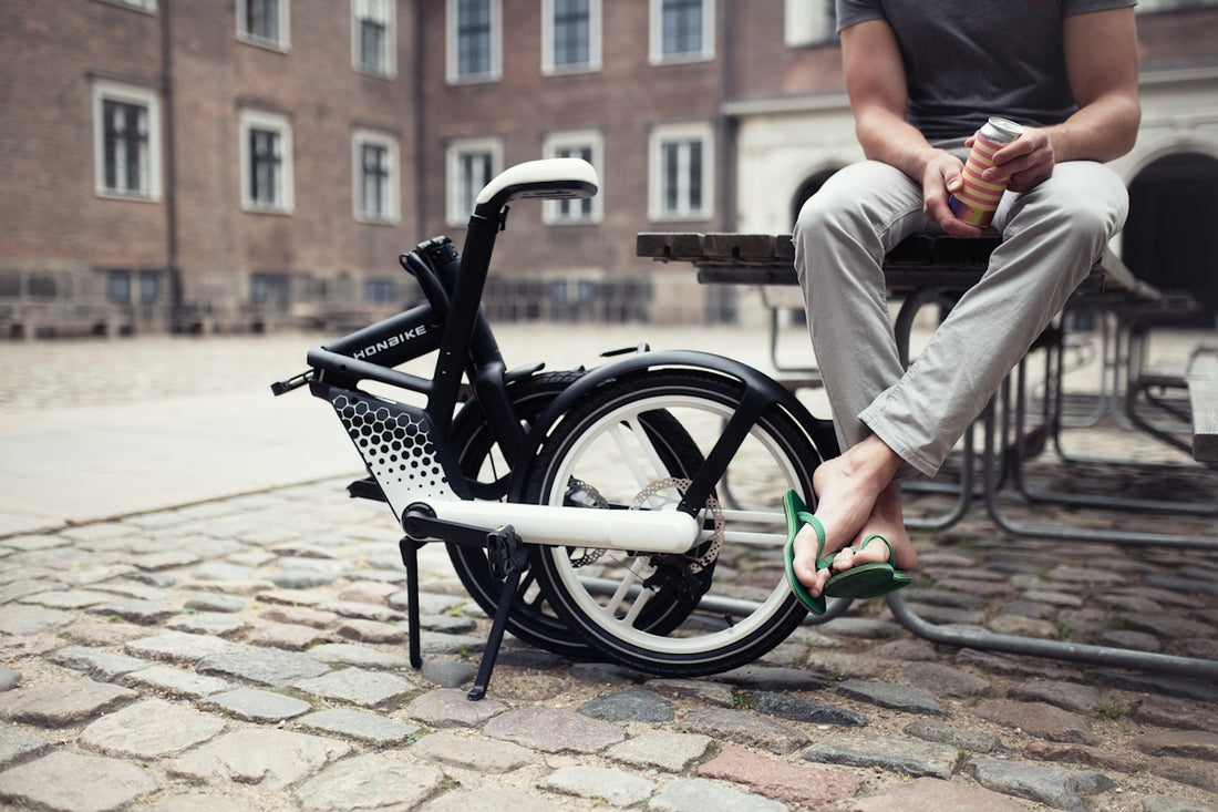 a person sitting on a bench next to a bicycle
