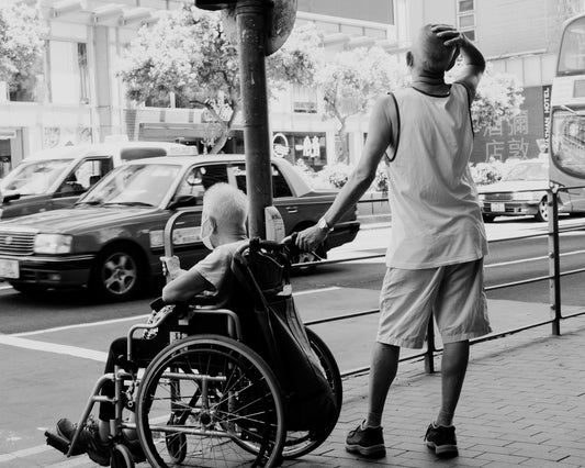 a man pushing a man in a wheelchair