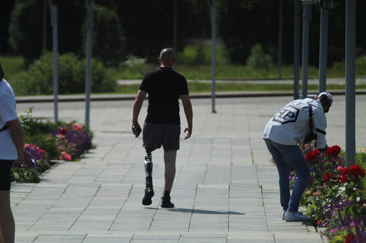 a man with a broken leg walking down a sidewalk