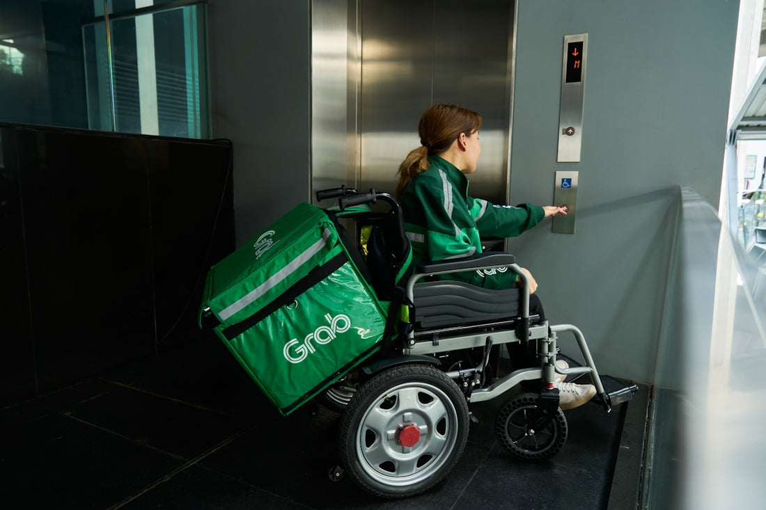 a woman in a wheel chair with a green bag