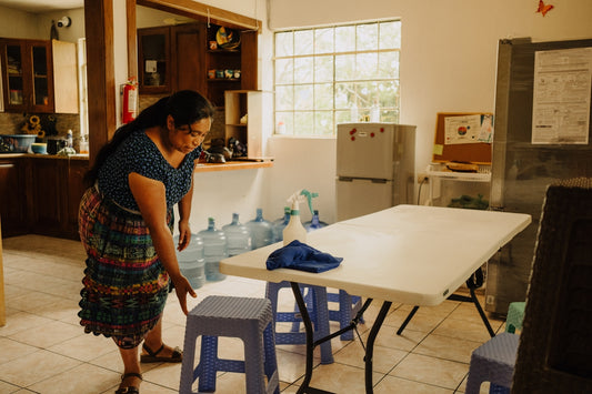 a woman standing in a kitchen next to a table