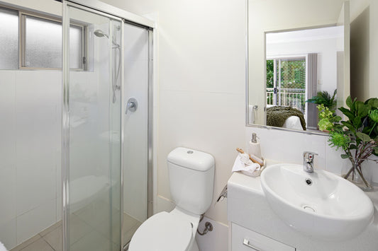 A bathroom with a toilet, sink, and shower