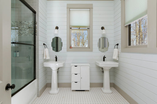 A white bathroom with two sinks and a shower