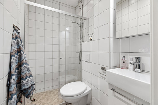 A bathroom with a toilet, sink, and shower