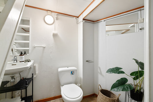 A bathroom with a toilet, sink, and stairs