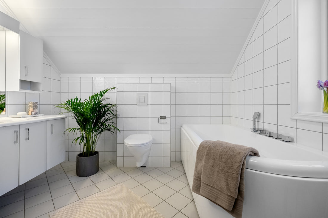 A bathroom with a tub, toilet, sink, and mirror