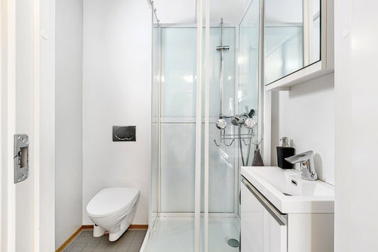 A bathroom with a toilet, sink, and shower