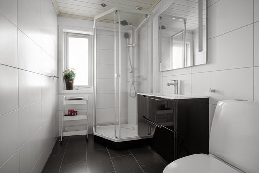 A bathroom with a toilet, sink, and mirror