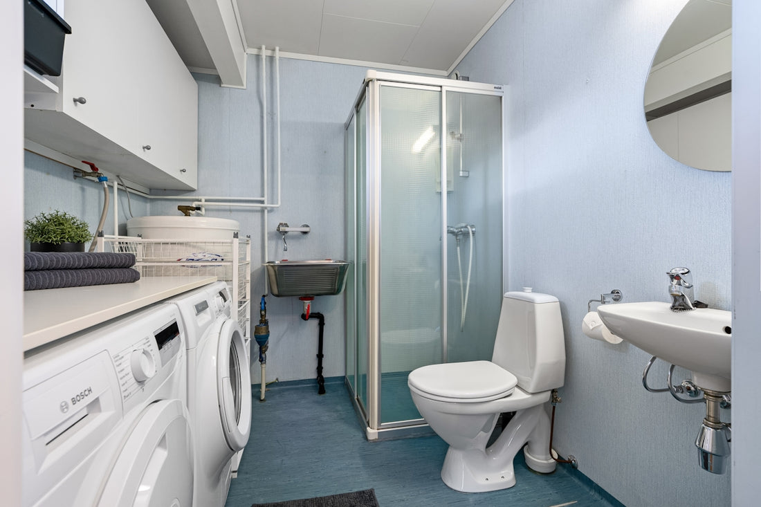 A bathroom with a toilet, sink, and washer and dryer
