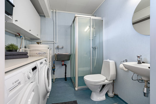 A bathroom with a toilet, sink, and washer and dryer