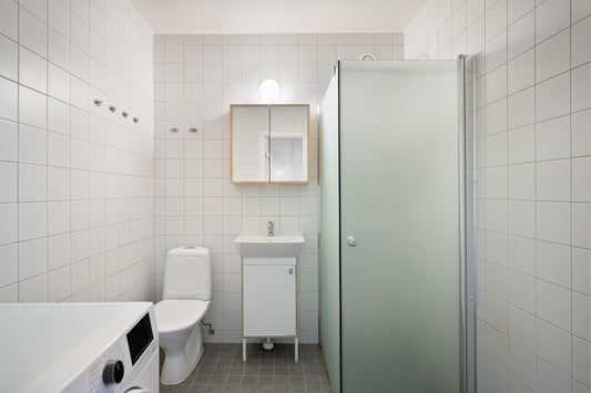 A bathroom with a toilet, sink, and shower stall