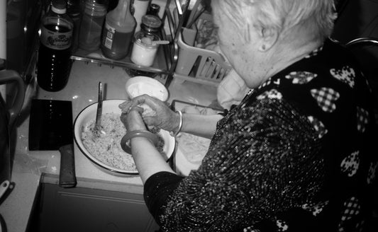 Elderly person preparing food in a kitchen.