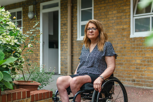 Woman in wheelchair outside brick building