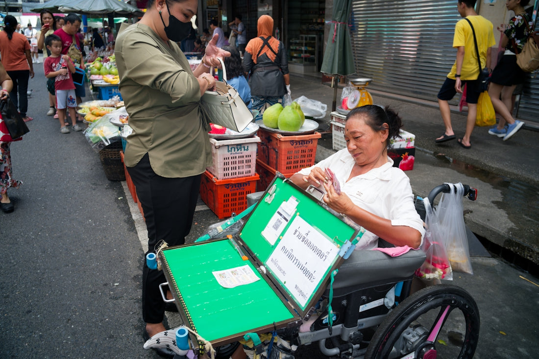 Woman in wheelchair selling items at market