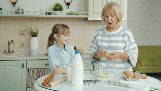 Grandmother and granddaughter baking together in kitchen