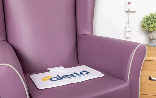 Alerta chair sensor alarm for elderly positioned on a purple armchair for fall prevention
